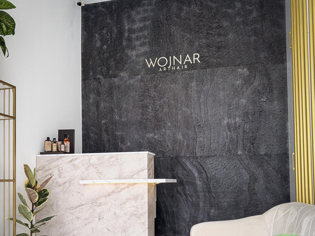 Wnętrze salonu Wojnar Art Hair — recepcja, marmur, logo na ścianie